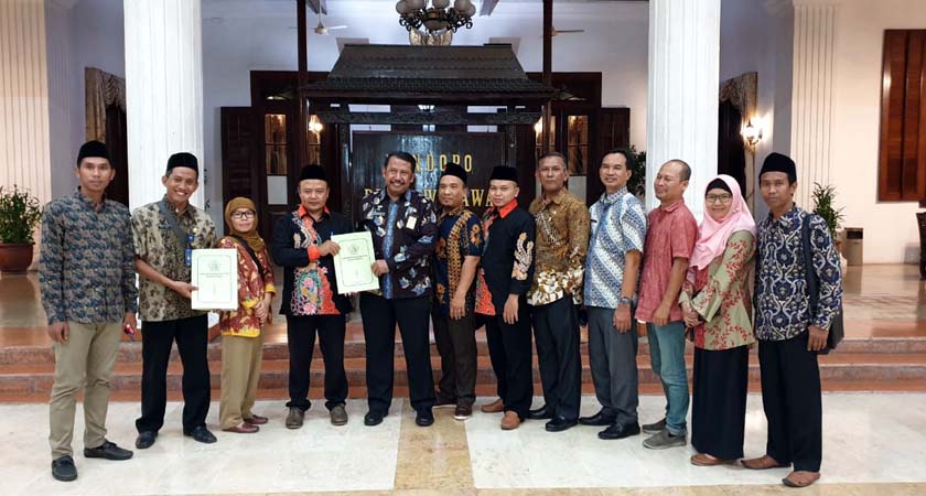 BERSAMA - Para Komisioner KPU dan Bawaslu Sidoarjo foto bersama dengan Kepala Bakesbangpol Pemkab Sidoarjo, Mulyawan usai penandatanganan Naskah Perjanjian Hibah Daerah (NPHD) Pilkada 2020 di Pendopo Delta Wibawa, Rabu (02/10/2019) malam