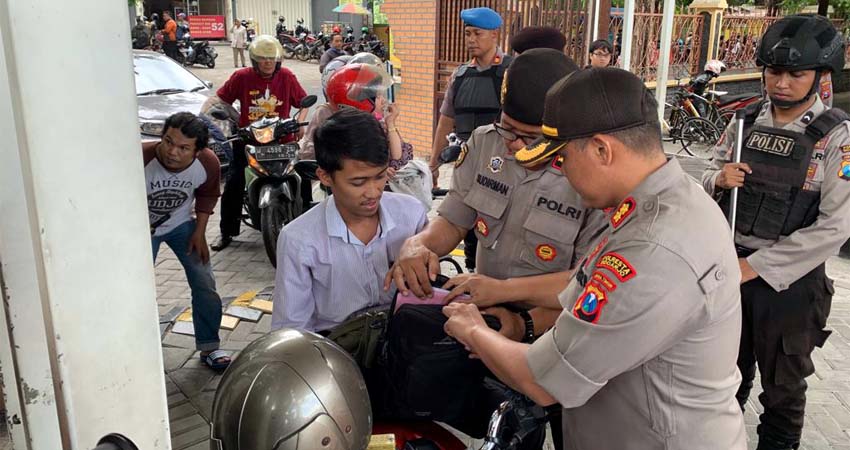 DIPERIKSA - Wakapolresta Sidoarjo, AKBP M Anggi Naulifar Siregar memimpin pemeriksaan pengunjung ke Polresta Sidoarjo baik yang menggunakan motor maupun mobil paska peristiwa ledakan di Polrestabes Medan, Rabu (13/11/2019)