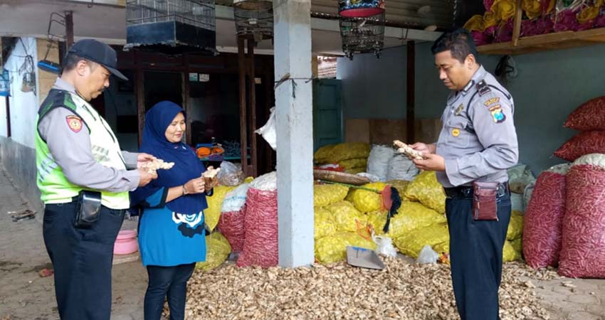 POLISI PEDULI JAHE - Muji'ah (tengah) dan anggota Polsek Krembung Aipda Bambang Irawan (kanan), Aiptu Ismail (kiri) menunjukkan jahe lokal dan jahe impor (gus)