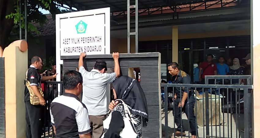 Papan bertuliskan Aset Pemerintah Kabupaten Sidoarjo, dicabut dan dirobohkan warga Desa Krembung (gus)