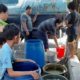 REBUTAN - Puluhan warga korban puting beliung Dusun Sidorono, Desa Barengkrajan, Kecamatan Krian, Sidoarjo berebut pasokan air bersih 5.000 liter dari PDAM Delta Tirta Sidoarjo, Senin (6/1/2020)