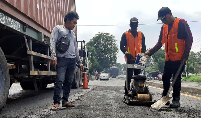 TAMBAL SULAM - Sejumlah pekerja menambal sulam aspal yang mengelupas dan berlubang di JL Raya Surabaya - Mojokerto sepanjang Kecamatan Balongbendo, Sidoarjo tetap masih banyak lubangnya, Rabu (4/3/2020)