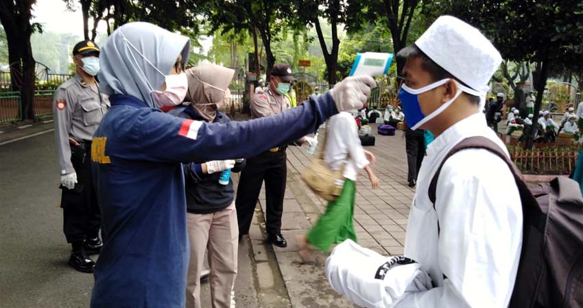 TES - Sebanyak 125 santri Pondok Pesantren Sidogiri, Pasuruan yang tiba di halaman parkir Masjid Agung Sidoarjo diperiksa kesehatan dan disemprot disinfektan, Kamis (2/4/2020)