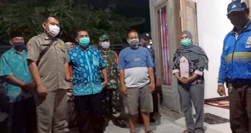 SEMBUH - Pemerintah Desa Jabaran, Kecamatan Balongbendo, Sidoarjo menyambut kedatangan Ny Riyayah (45) pasien Covid-19 sembuh didampingi petugas Polsek, Koramil dan keluarga, Minggu (17/05/2020) malam