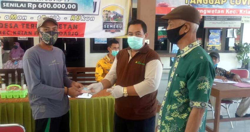 Kepala Desa Terungwetan, Mat Kojim ( Kanan ) menyaksikan penerimaan BLT DD tahap ke 2 (par)