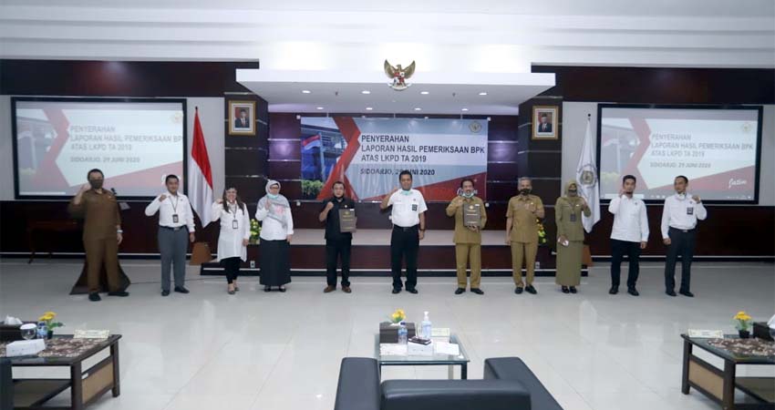 WTP - Kepala BPK Perwakilan Provinsi Jatim Joko Agus Setyono menyerahkan Opini Wajar Tanpa Pengecualian (WTP) atas Laporan Keuangan Pemerintah Daerah (LKPD) Tahun 2019 ke Plt Bupati Sidoarjo, Nur Ahmad Syaifuddin dan Ketua DPRD Sidoarjo, Usman di Kantor BPK Perwakilan Jatim, Senin (29/06/2020)