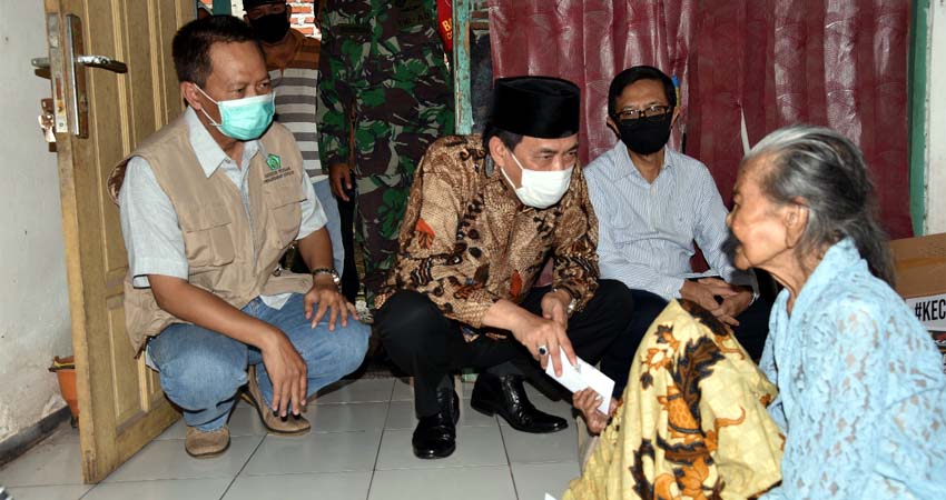 BANTUAN - Plt Bupati Sidoarjo, Nur Ahmad Syaifuddin menyerahkan bantuan sembako dan uang tunai untuk Wagina (90) warga Kelurahan Urangagung, Kecamatan Sidoarjo yang hidup sebatang kara dan hidup mengandalkan belas kasian dari warga sekitar, Senin (1/6/2020)