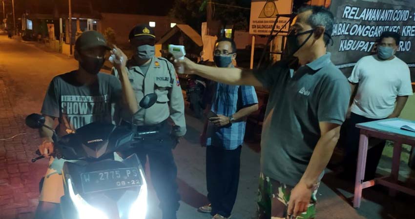 Pj. Kepala Desa Balonggarut H Sultoni bersama tim relawan saat melakukan check point pada pengendara yang memasuki jalan desa. (gus)