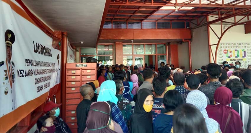 LANGGAR PROTOKOL - Ratusan warga mengantre pencairan Bantuan Sosial Tunai (BST) di Kantor Pos Cabang Sidoarjo tanpa mengindahkan protokol kesehatan karena antreannya tak berjarak sama sekali, Kamis (11/06/2020)