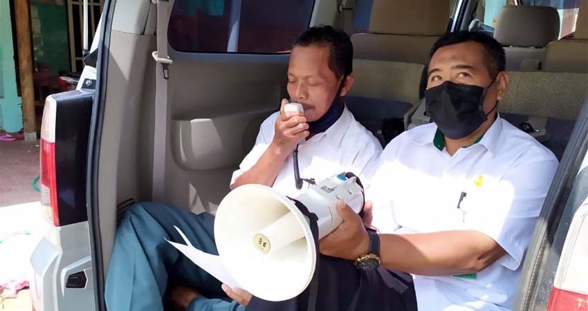 Kepala Dusun Bogem Suyadi (kanan), saat menghimbau warganya dengan menggunakan mobil operasional Desa Keper dan Tim relawan Desa Keper, berada di pos check point antisipasi Covid-19. (gus)