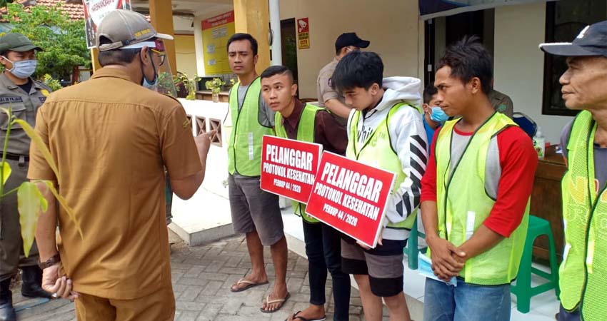 SANKSI SOSIAL - Sebanyak 26 pengendara yang terjaring operasi masker 15 diantaranya disanksi sosial bersih-bersih sisanya 11 orang disita KTP hingga 14 hari ke depan saat razia gabungan di depan kantor Kecamatan Krian, Senin (06/07/2020)