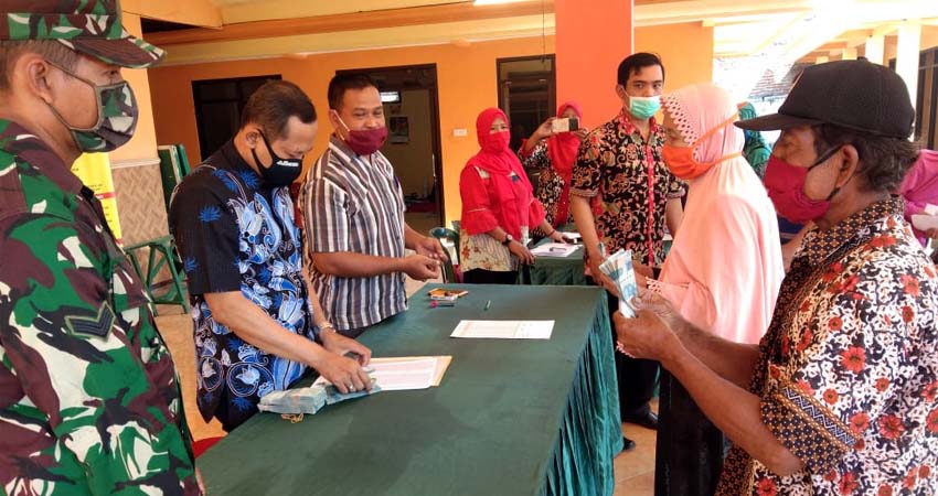 Pj. Kepala Desa Kedinding , Ludi Dwi Julianto ( tiga dari kiri ) menyaksikan penyaluran BLT DD tahap II.(par)