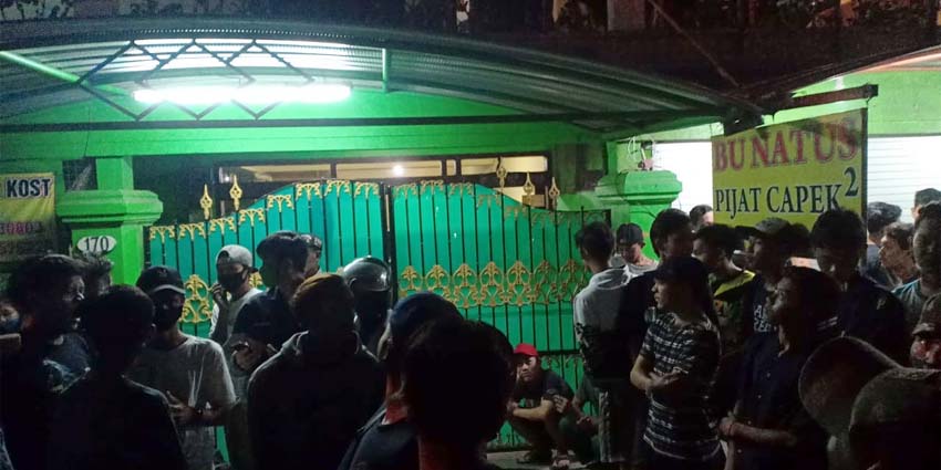 PENASARAN - Ratusan warga berkumpul di depan rumah korban Tin Kartini (70) pemilik rumah pijat Bu Natus di JL Brigjen Katamso No 170 Desa Kedungrejo, Kecamatan Waru, Sidoarjo, Jumat (24/7/2020) malam