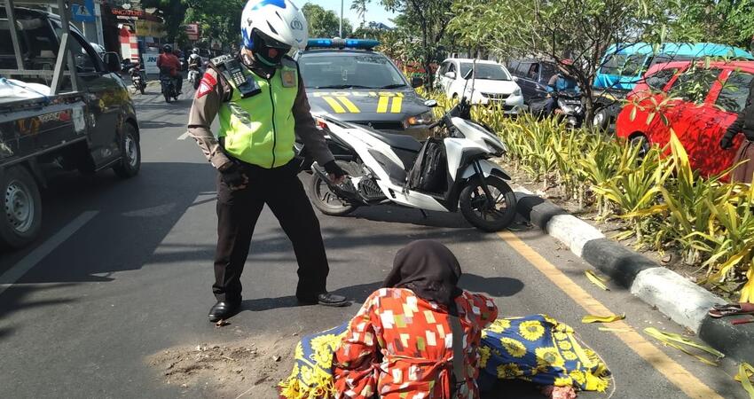 EVAKUASI: Petugas mengevakuasi jenazah, Ny Hartik (54) warga Keputran Pasar Kecil, Kecamatan Tegalsari, Surabaya yang tewas terlindas truk di JL Raya Desa/Kecamatan Buduran, Sidoarjo, Senin (12/10/2020).